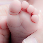 pés de um bebê nas mãos da mãe